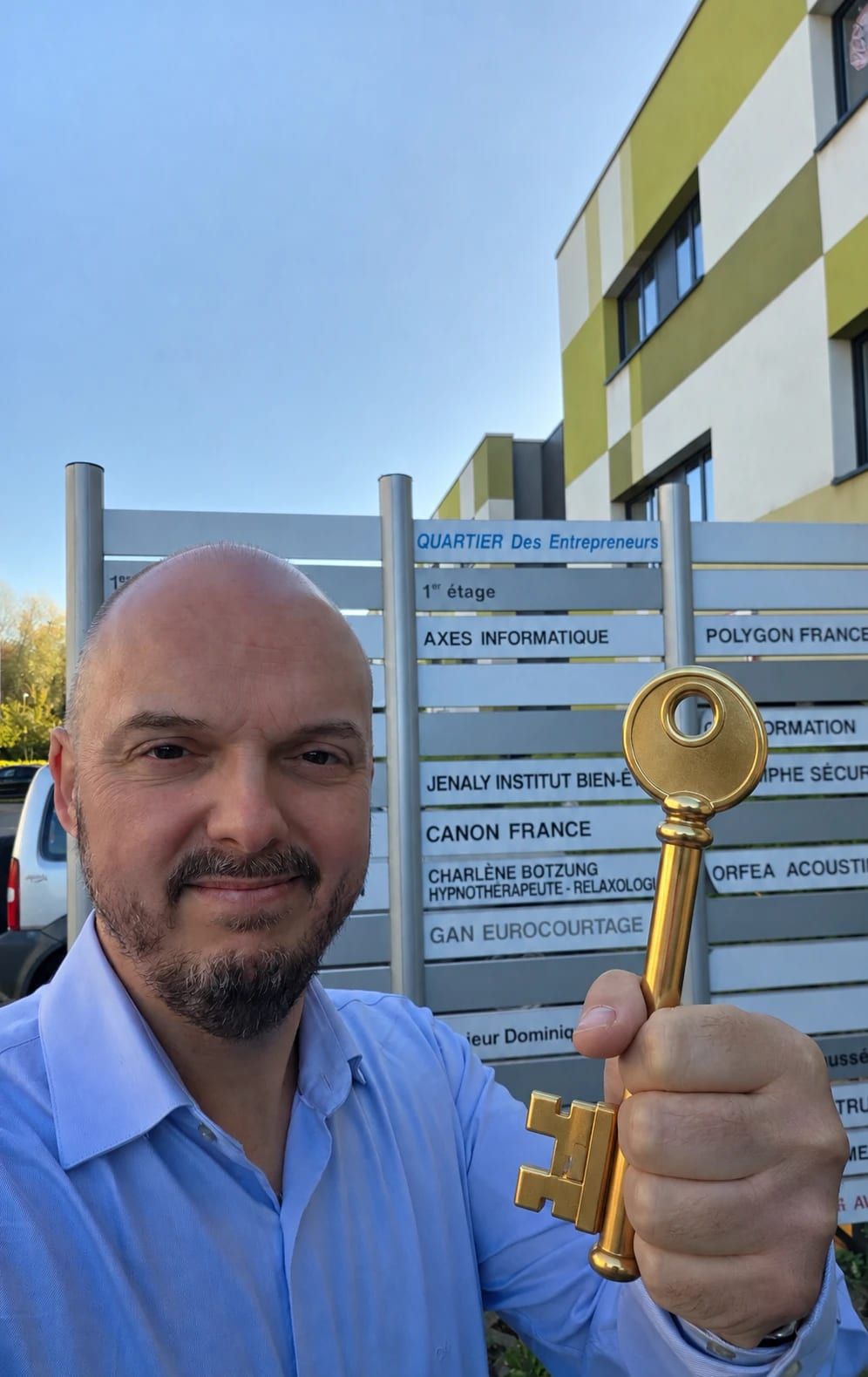 Thibault Charette, président d'Atrium, tenant une clé dorée devant le panneau du Quartier des Entrepreneurs à Metz